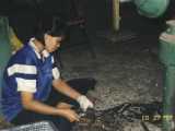 A Thailand 'factory'. There are many such factories where hand made products are made and sold in a store next door. In this case, this woman is taking bronzeware out of molds and cutting off the rough edges.